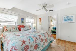 um quarto com uma cama e uma ventoinha de tecto em The Seashell Cottage em Anna Maria