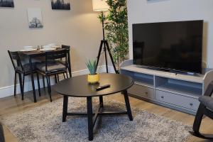 a living room with a coffee table and a flat screen tv at Park House Modernised 2 Bedroom Property in Knowsthorpe