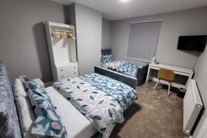 a bedroom with two beds and a desk and a mirror at Park House Modernised 2 Bedroom Property in Knowsthorpe