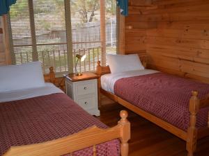 1 dormitorio con 2 camas y ventana en Coles Bay House en Coles Bay