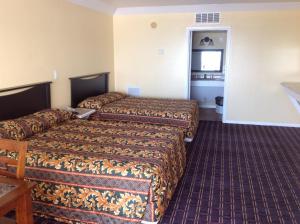 a hotel room with two beds and a refrigerator at Sea Shell Inn on the Beach in Corpus Christi