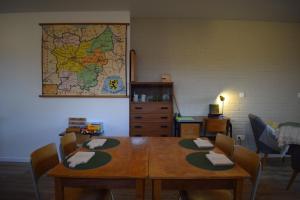 una sala da pranzo con tavolo e mappa sul muro di B&B Houten Huis a Nazareth
