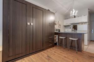 a kitchen with a large wooden cabinet and two bar stools at Initial / Aube / Québec in Quebec City +14 photos