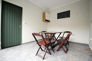 a table and chairs in a room with a green door at Casa de Temporada Gagiges in Olímpia