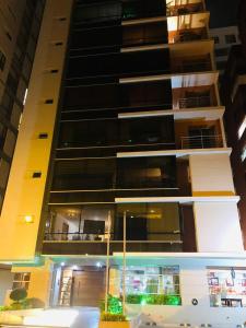 een hoog appartementencomplex 's nachts met een gebouw bij Elegante suite amoblada - Park La Carolina cerca Hotel Dann Carlton in Quito