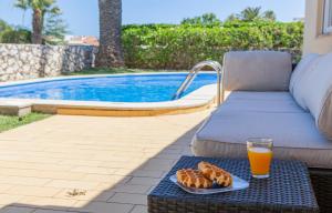 uma bandeja de pão e sumo de laranja numa mesa ao lado de uma piscina em N - Astonishing Bay View Guesthouse em Lagos