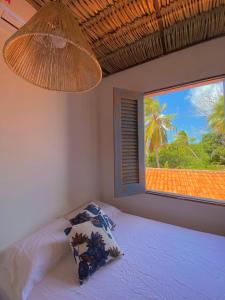a bedroom with a bed and a window with a view at Casa Nature Atins in Atins
