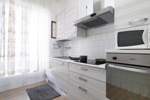 een keuken met witte kasten en een magnetron bij Casa Primavera in Bergamo