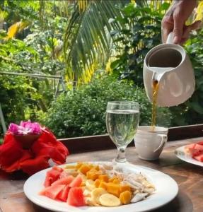 a plate of fruit and a cup of coffee on a table at The Green Station in Dickwella