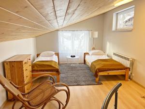 a room with two beds and a table and chairs at Mountain View in Krynica Zdrój