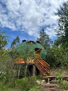 un antiguo edificio con una cúpula verde en una colina en cabaña tipo domo 100% equipado, en Nobsa