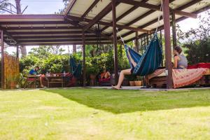 谷安東的住宿－Bodhi Hostel & Lounge，坐在凉亭下吊床上的女人