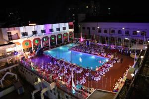 una vista aérea de una piscina por la noche con una fiesta en Moti Mahal, en Mangalore