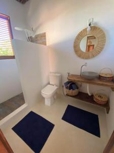 ein Badezimmer mit einem WC, einem Waschbecken und einem Spiegel in der Unterkunft Casa Nature Atins in Atins