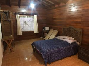 1 dormitorio con 1 cama en una cabaña de madera en Estancia LOS FUNDADORES en Comalcalco