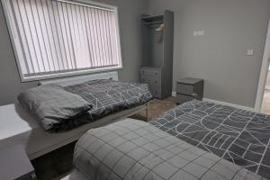 Duas camas num quarto com uma janela em Modernised 4 Bedroom Property Close To City Centre, Harehills Lane em Roundhay