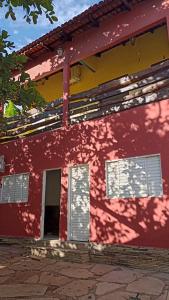 a red building with white shutters on it at Pousada Acalanto in Pirenópolis +36 photos