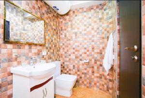 a bathroom with a sink and a toilet and a mirror at Dilijan Dream House! 3 Bedroom Amazing Villa in National Park! in Dilijan