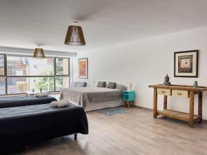 1 dormitorio con 2 camas, mesa y ventana en Depto 5 p. Centro de Bariloche en San Carlos de Bariloche