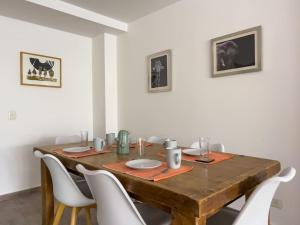 comedor con mesa de madera y sillas blancas en Depto 5 p. Centro de Bariloche en San Carlos de Bariloche