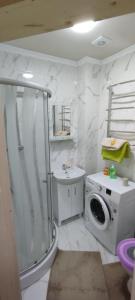y baño con ducha y lavadora. en Гостинний двір Матійчуків Новий, en Vorokhta