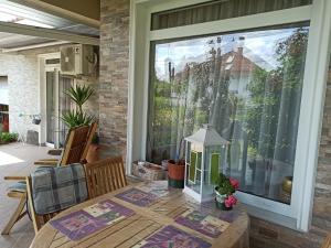 un porche avec une table et une grande fenêtre dans l'établissement Harmath Vendégház Balatonszárszó, à Balatonszárszó
