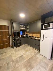 cocina con refrigerador blanca y fogones en AIKEN 9 SOL en San Martín de los Andes