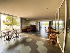 a room with tables and chairs and a dining room at Cabo Frio - Loft Premium Royalle in Cabo Frio