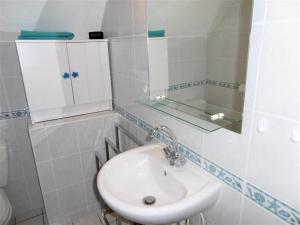 Baño blanco con lavabo y espejo en Maisonnette Youenn, en Sarzeau