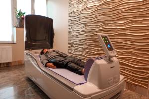 a man laying on a hospital bed in a room at Health & Wellness Center Energetikas in Šventoji