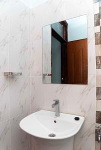 ein Bad mit einem Waschbecken und einem Spiegel in der Unterkunft Springstone executive apartment Rm 15 in Langata Rongai