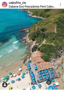 an aerial view of a beach with umbrellas and the ocean at Cabo Frio - Loft Premium Royalle in Cabo Frio