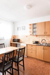 a kitchen with wooden cabinets and a table and chairs at ClickTheFlat Constitution Square Apart Rooms in Warsaw