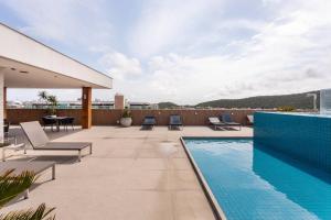 a patio with a swimming pool on top of a building at Cabo Frio - Loft Premium Royalle in Cabo Frio