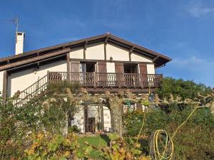 a house with a balcony on the side of it at Maison Barbarenekoborda in Villefranque