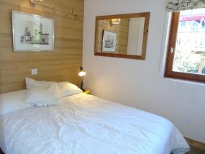 a bedroom with a white bed and a mirror at Charmant Appartement avec Mezzanine et Balcon - 4-5 Pers., Garage, Proche Lac et Navette - FR-1-198-121 in Châtel