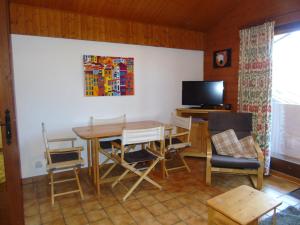 a living room with a table and chairs and a television at Appartement spacieux 6 personnes avec balcon à Châtel - FR-1-198-127 in Châtel +10 photos