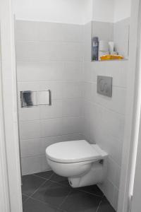een wit toilet in een wit betegelde badkamer bij Prince Matyas apartment in Praag