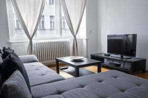 a living room with a couch and a tv at Prince Matyas apartment in Prague