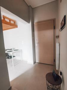 Zimmer mit einer Tür, einem Stuhl und einem Tisch in der Unterkunft Efrosini's by the sea apartment in Chalkida