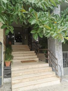 eine Gruppe Treppen mit einem großen Baum darüber in der Unterkunft Efrosini's by the sea apartment in Chalkida