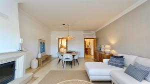 ein Wohnzimmer mit einem weißen Sofa und einem Tisch in der Unterkunft Adam's Place (Garça Real)CD242 - Clever Details, Sleeps 4 people, Wifi, Garage in Vilamoura
