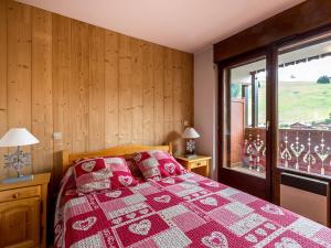 a bedroom with a bed and a large window at Charmant appartement proche ski et village, animaux admis - FR-1-437-31 in La Clusaz