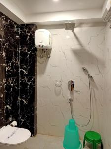 ein Bad mit einem WC und einer Dusche in einer Wand in der Unterkunft Hotel Morning Glow in Digha