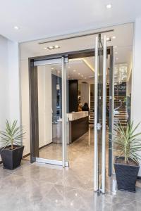 un vestíbulo con puertas de cristal y dos macetas en HOTEL M en Mendoza