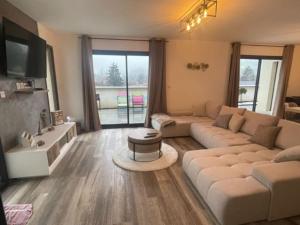 ein Wohnzimmer mit einem weißen Sofa und einem TV in der Unterkunft Cassie Home in Saint-Jean-en-Royans