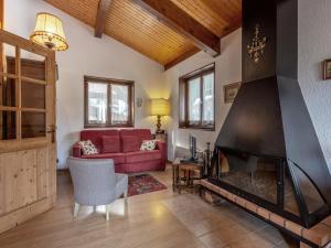 a living room with a red couch and a fireplace at Appartement La Clusaz, 3 pièces, 6 personnes - FR-1-437-44 in La Clusaz