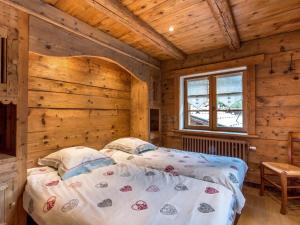 a bedroom with a bed in a log cabin at Appartement La Clusaz, 6 pièces, 10 personnes - FR-1-437-51 in La Clusaz