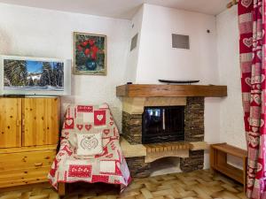 a living room with a fireplace and a chair at Appartement cosy, proche pistes et centre, 3 pièces, 6 pers, cheminée, balcon, parking - FR-1-437-53 in La Clusaz