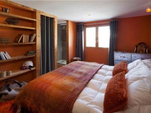 拉克呂薩的住宿－Chalet La Clusaz, 6 pièces, 12 personnes - FR-1-437-57，一间卧室配有一张带橙色墙壁和窗户的床